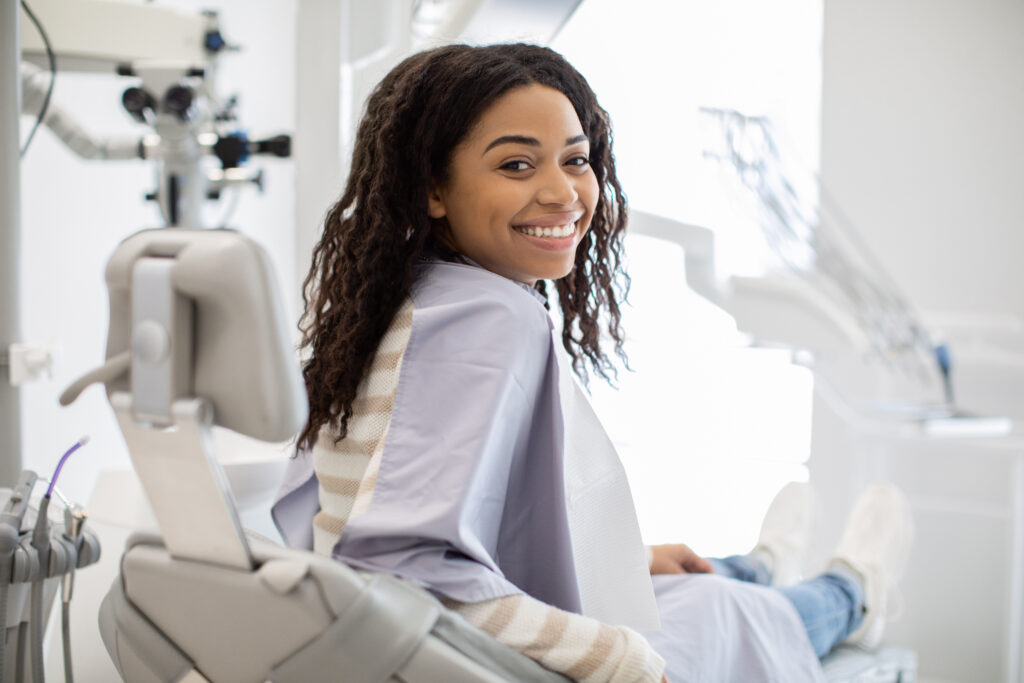 Smiling woman with curly hair seated in a dental chair
