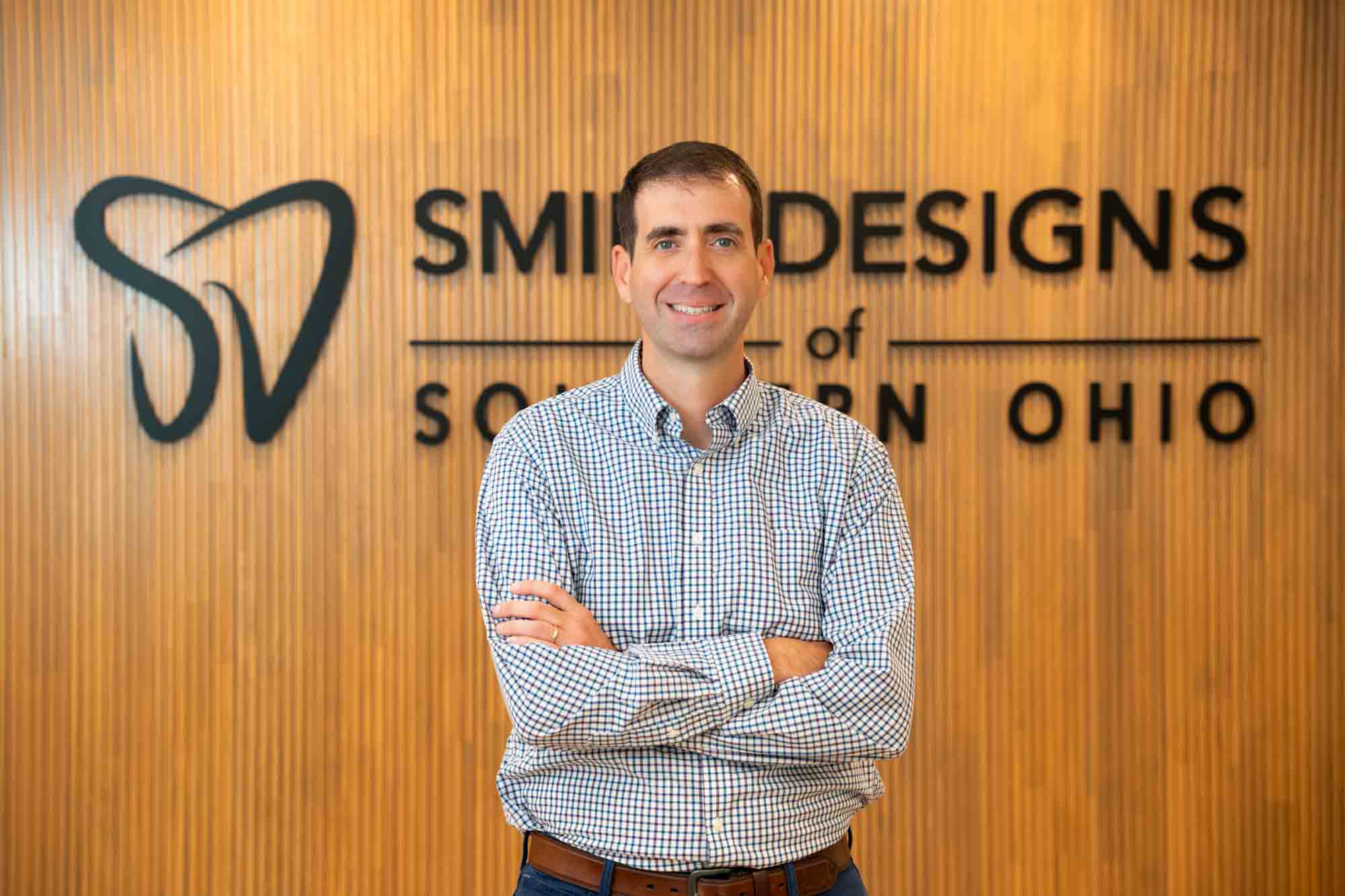 Dr. Ben McDonald standing in front of the Smile Designs of Southern Ohio sign