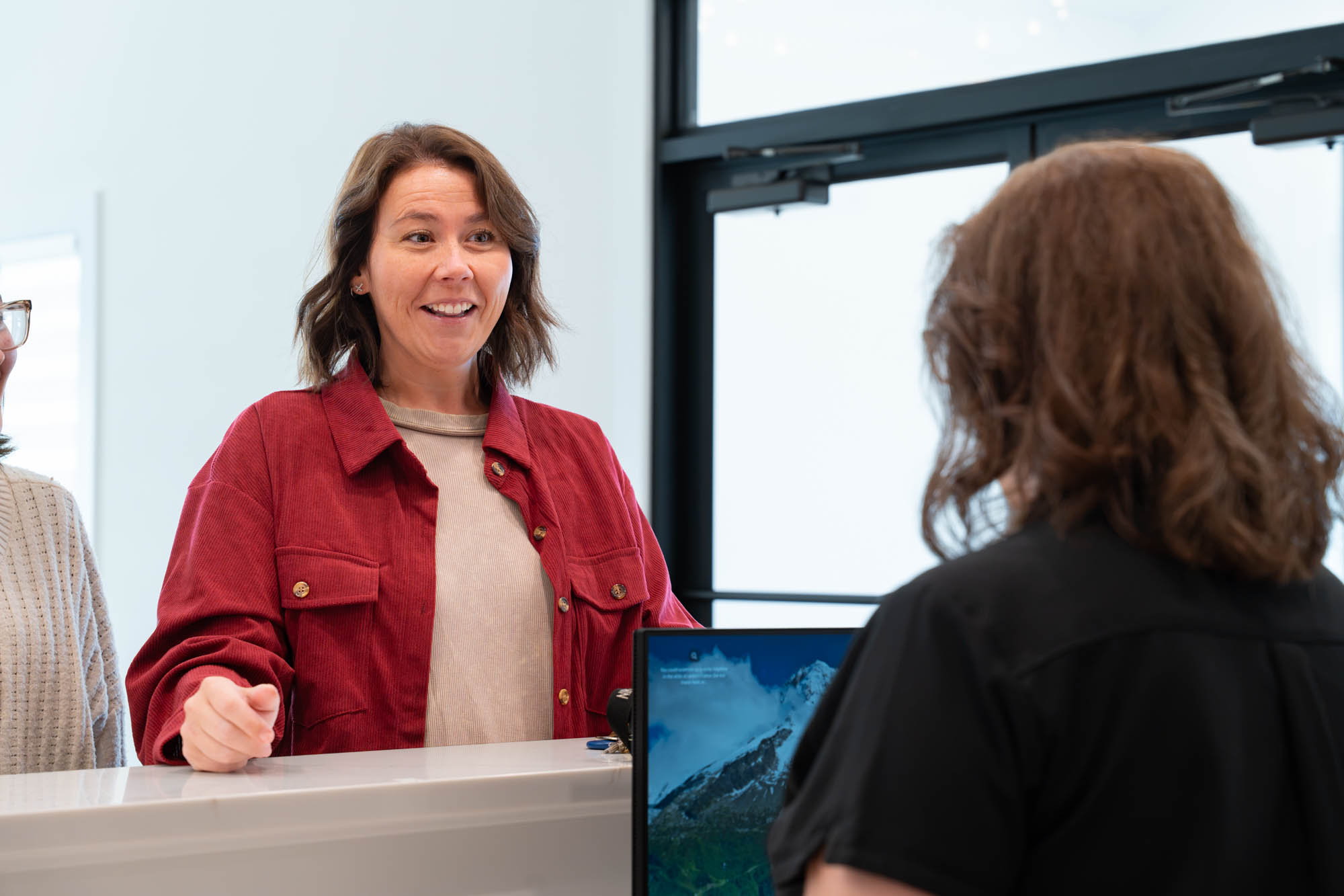 Smiling mother talking with the front desk team
