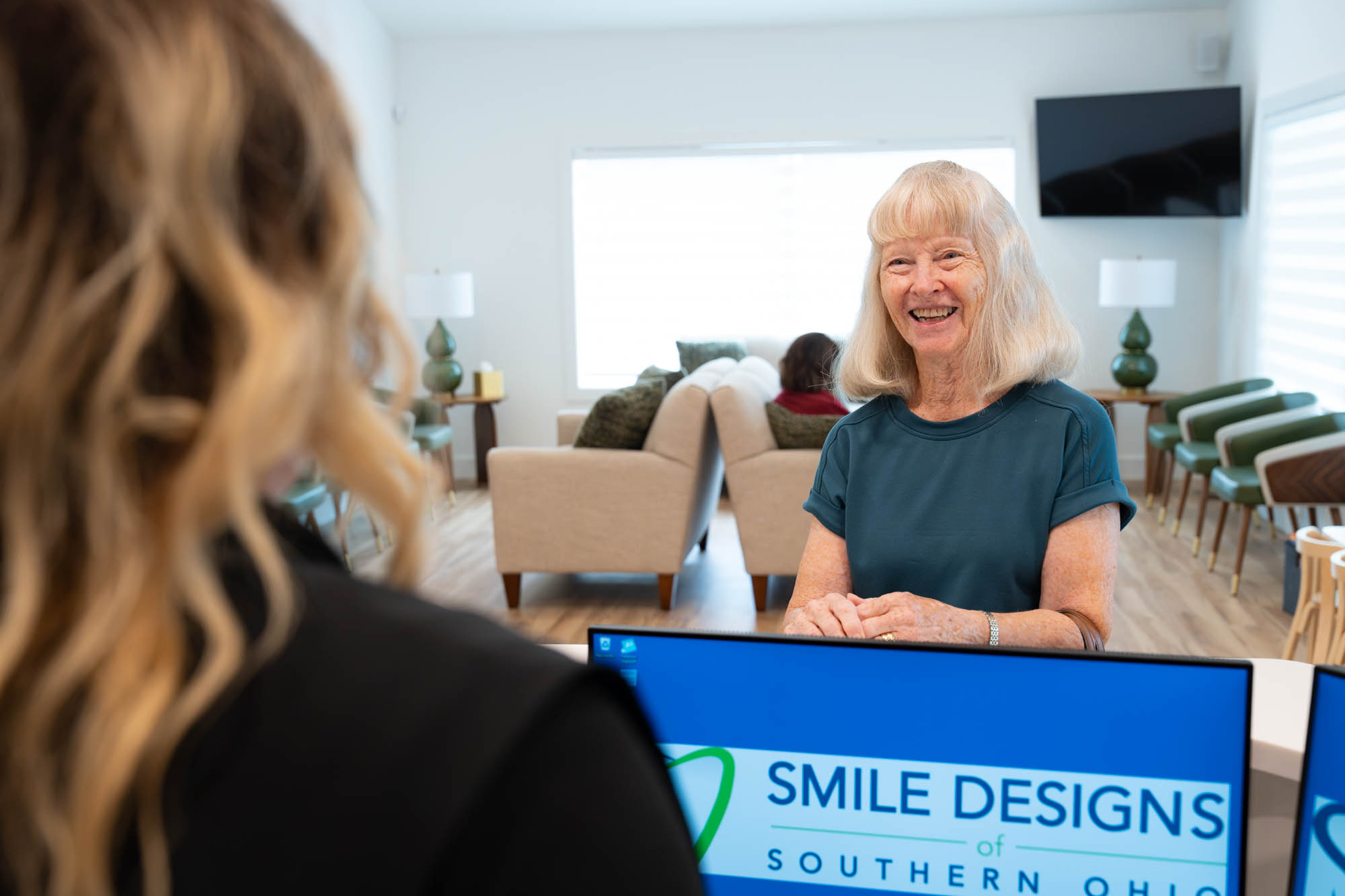 Patient laughing with the front desk team