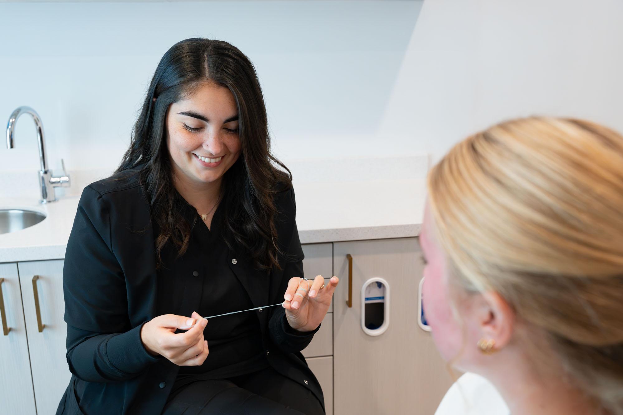 Team member showing a patient how to care for a clear aligner