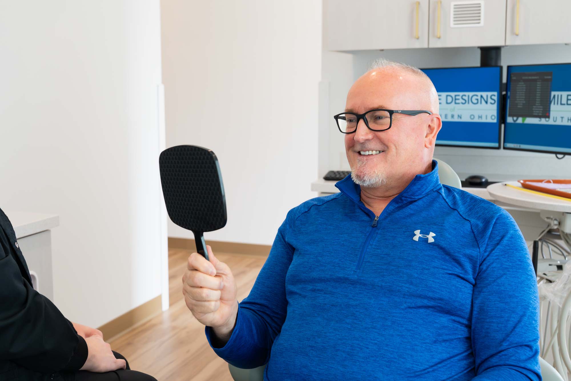 Patient checking his smile in a hand mirror