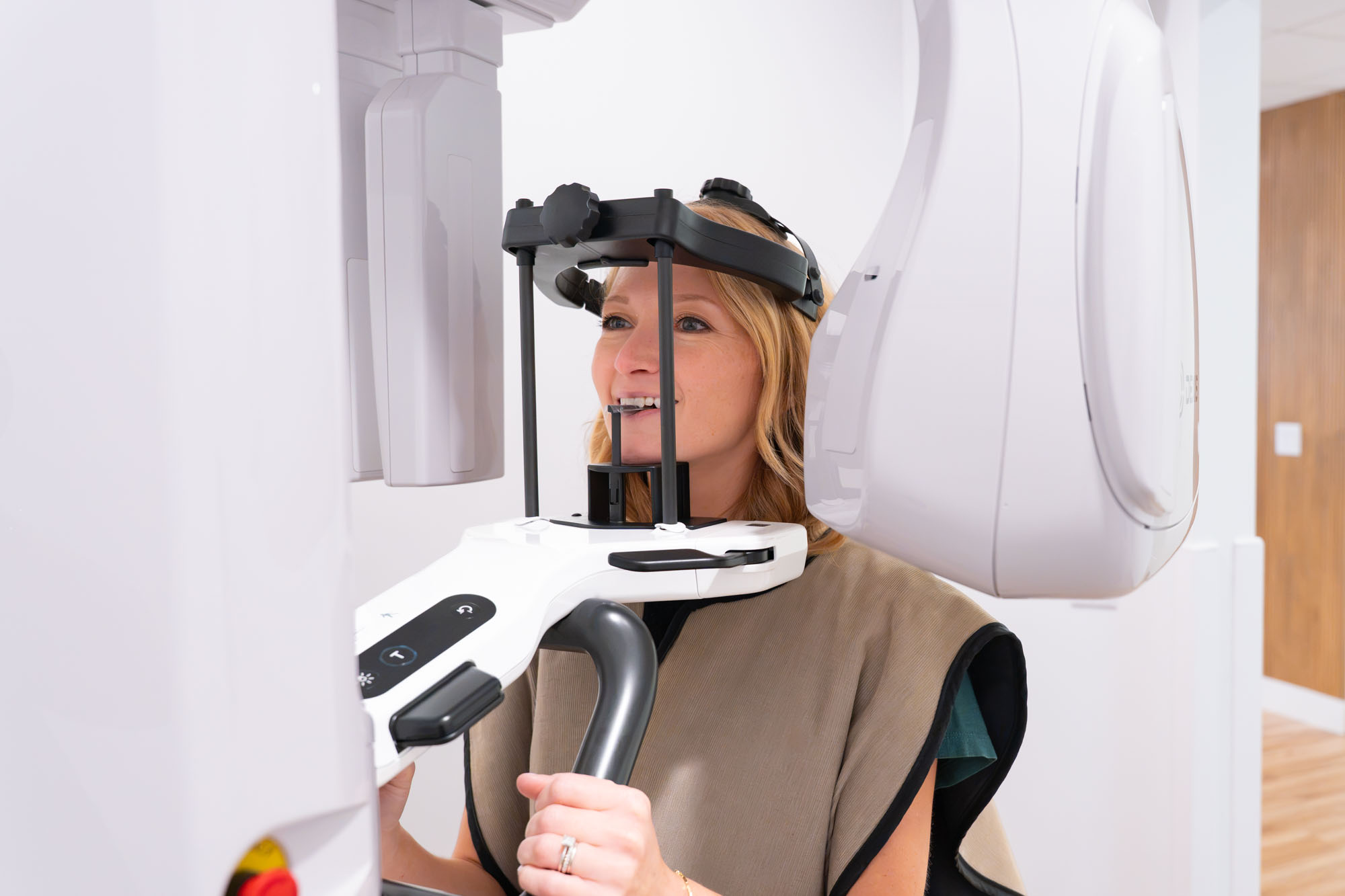 Smiling patient positioned in the 3D imaging machine
